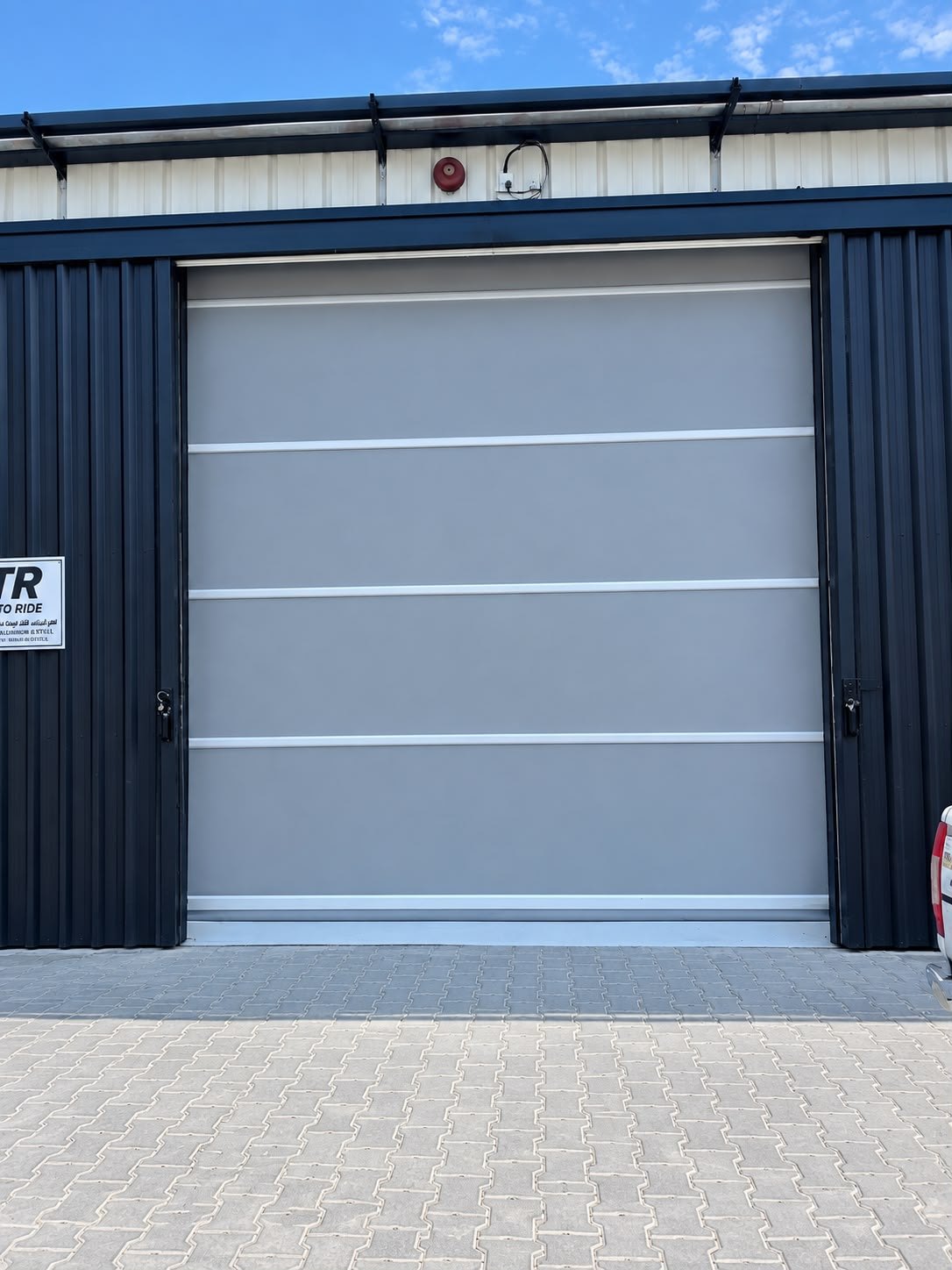 Grey high-speed roll door installed on an industrial unit in Al Quoz, Dubai