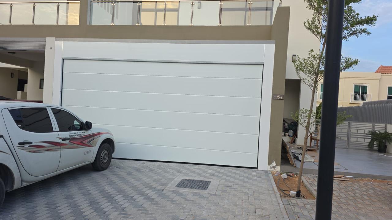 Smooth plain white sectional garage door installed on a villa in Ajman