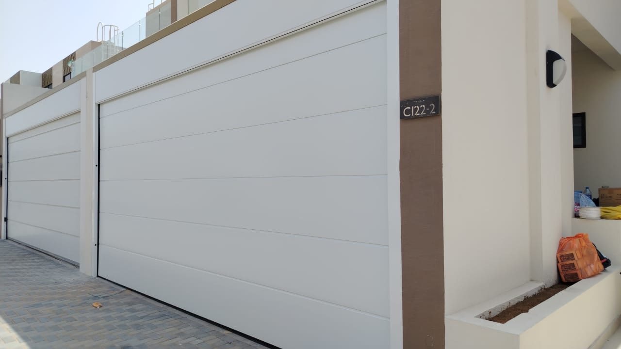 Smooth white automatic garage doors on villa garages in The Fields, Dubai