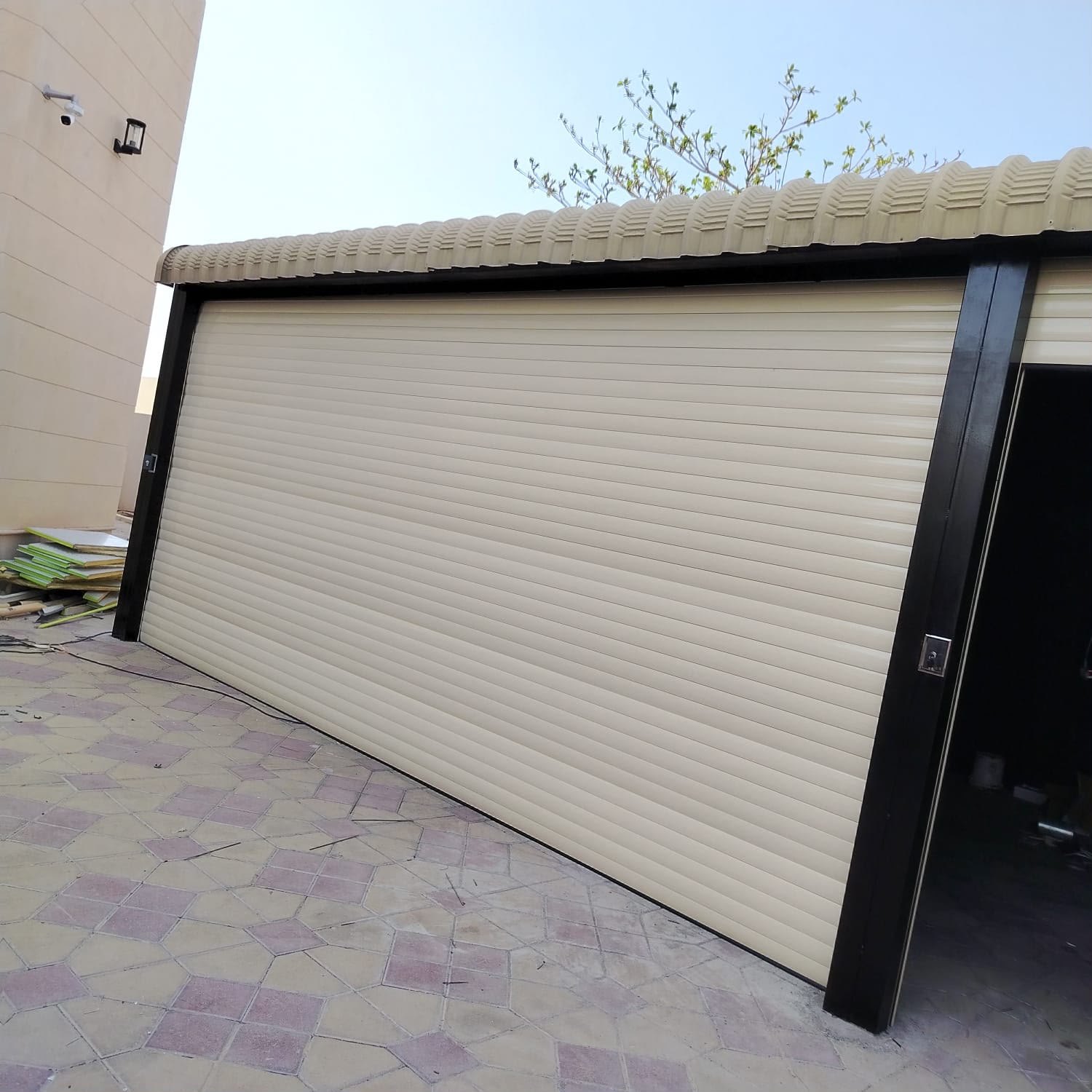 Cream double skin insulated rolling shutter in a black steel frame installed in Al Qusais, Dubai
