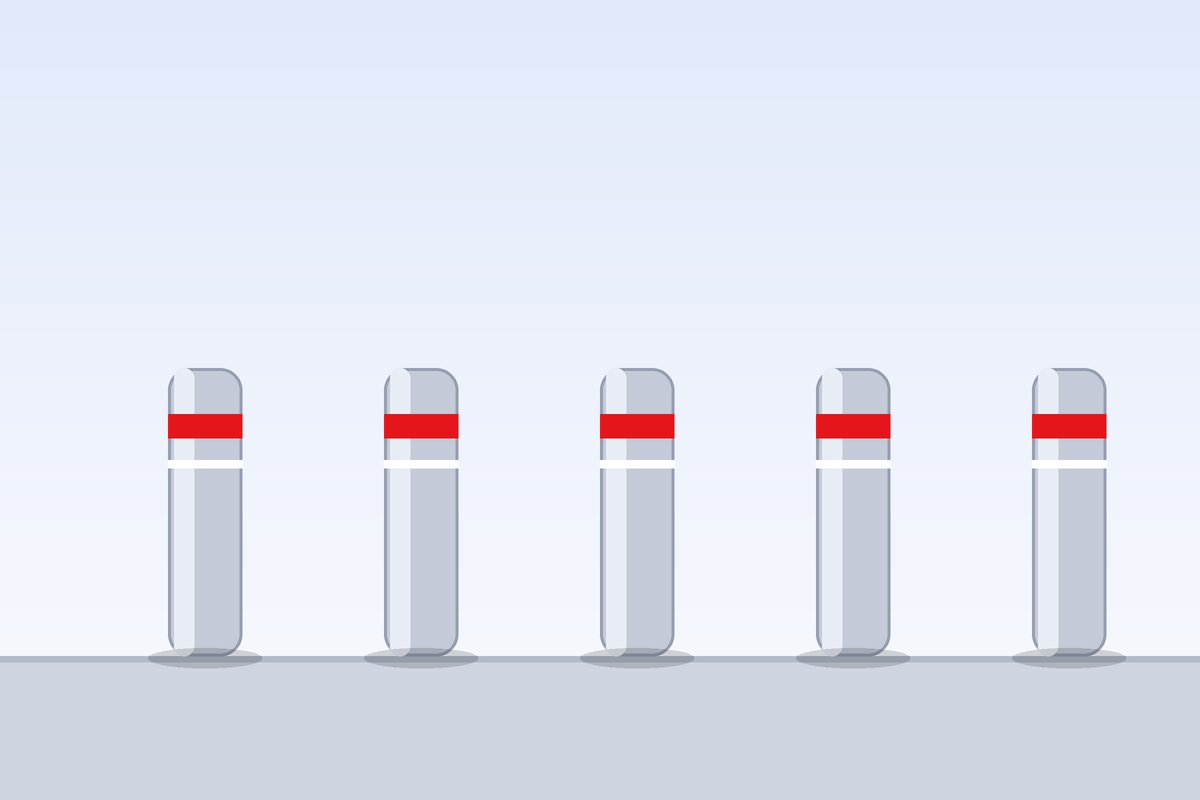 Row of steel bollards with reflective bands protecting a building entrance