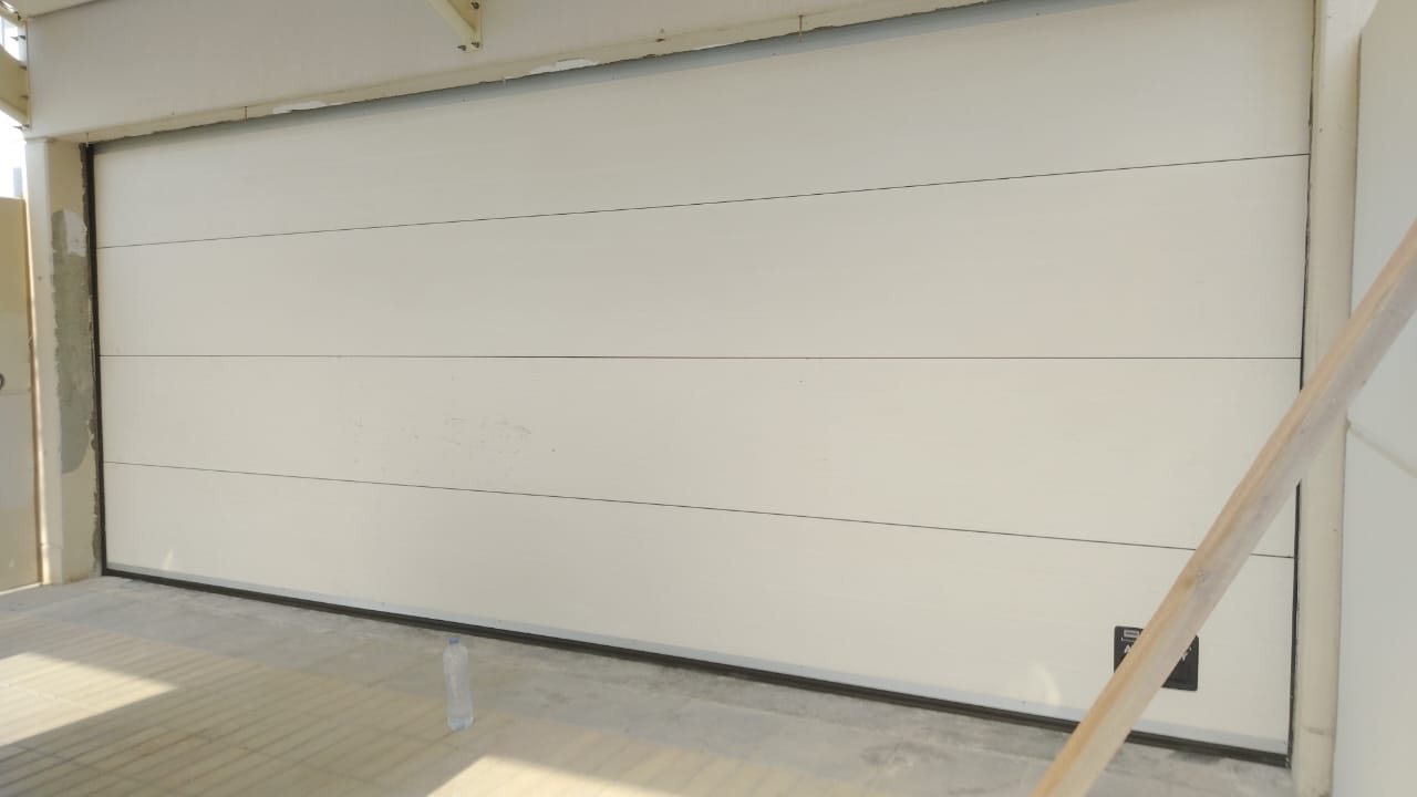 Smooth white sectional garage door re-installed in a villa in Meydan, Dubai