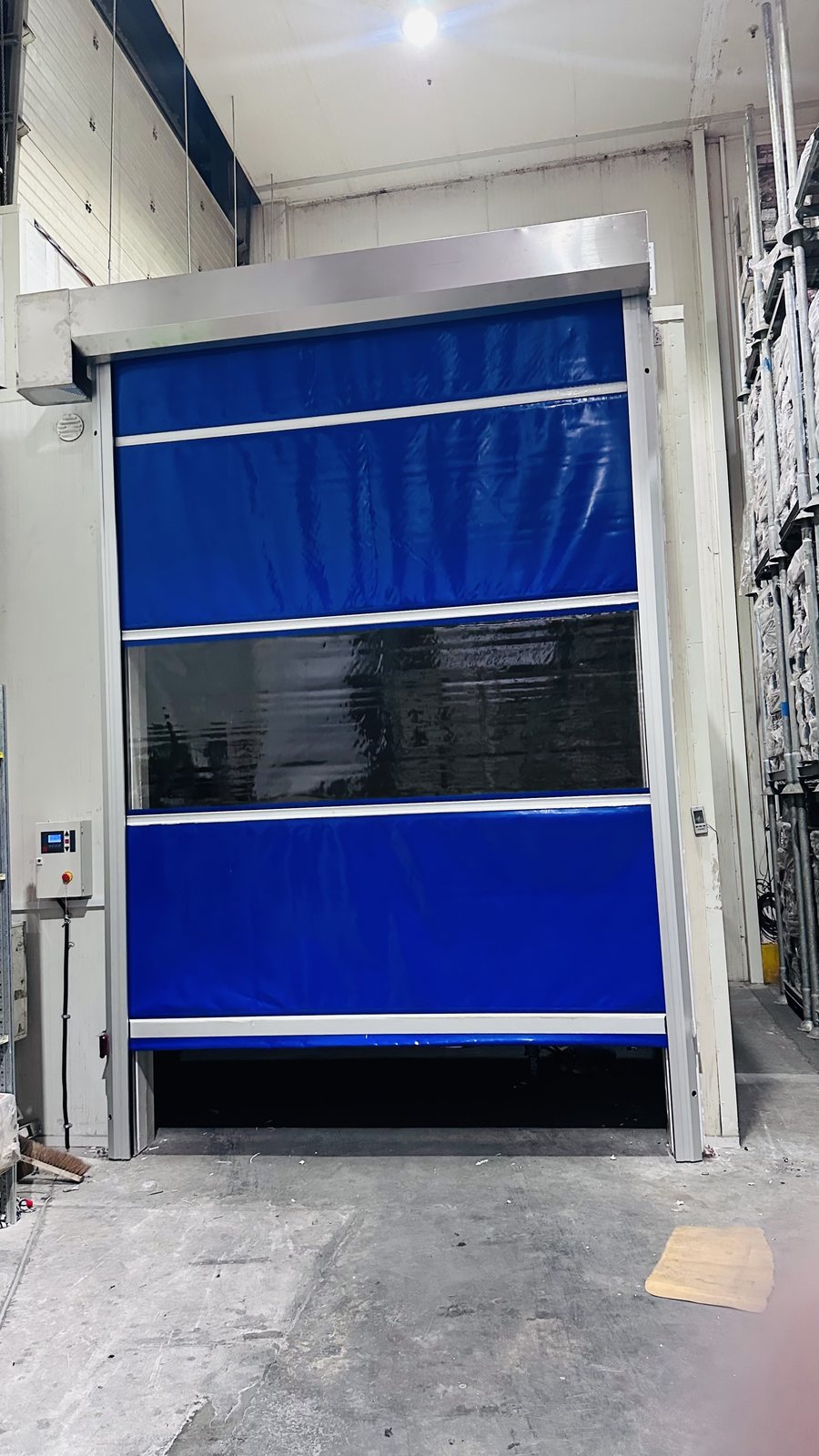 Blue PVC fabric high-speed door with vision panel installed in a warehouse in Dubai Industrial City